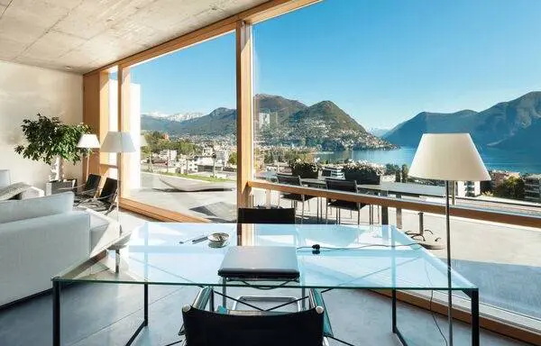 A glass table with chairs and tables in front of a window.