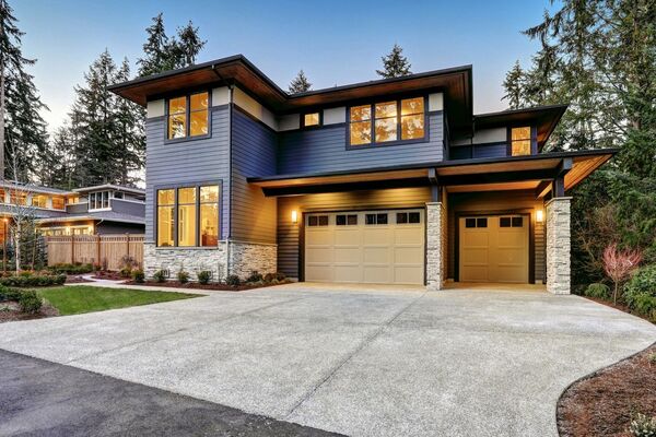 A large blue house with two garage doors.