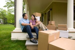 A man and woman sitting on steps near boxes.