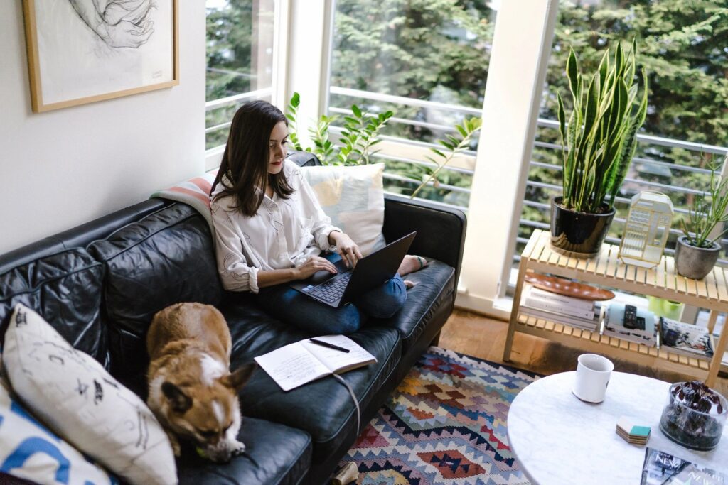 A woman sitting on top of a black couch.