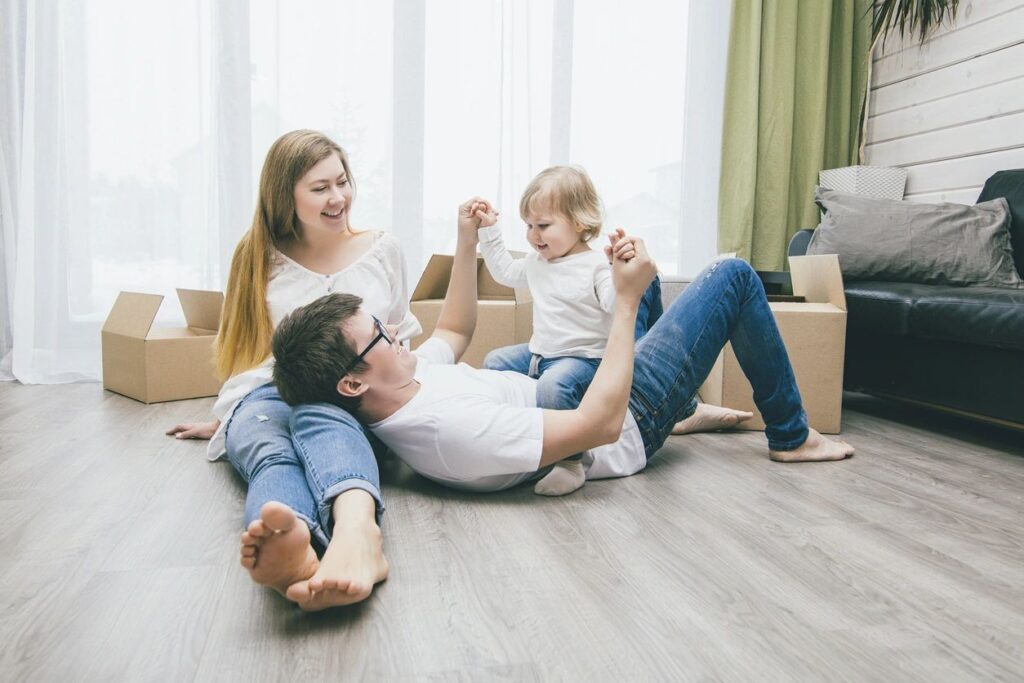 A man and woman sitting on the ground with a child.