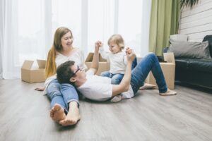 A man and woman sitting on the ground with a child.