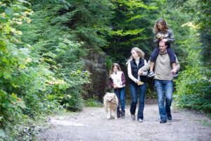 A family walking down the road with their dog.