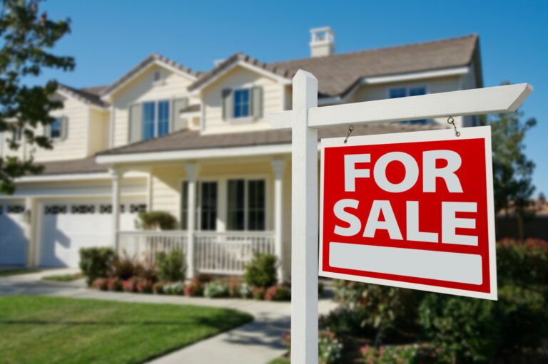 A for sale sign in front of a house.