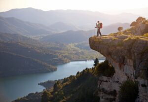 A man standing on top of a cliff with a backpack.