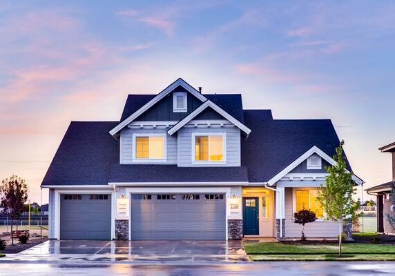 A house with two garage doors and a blue sky